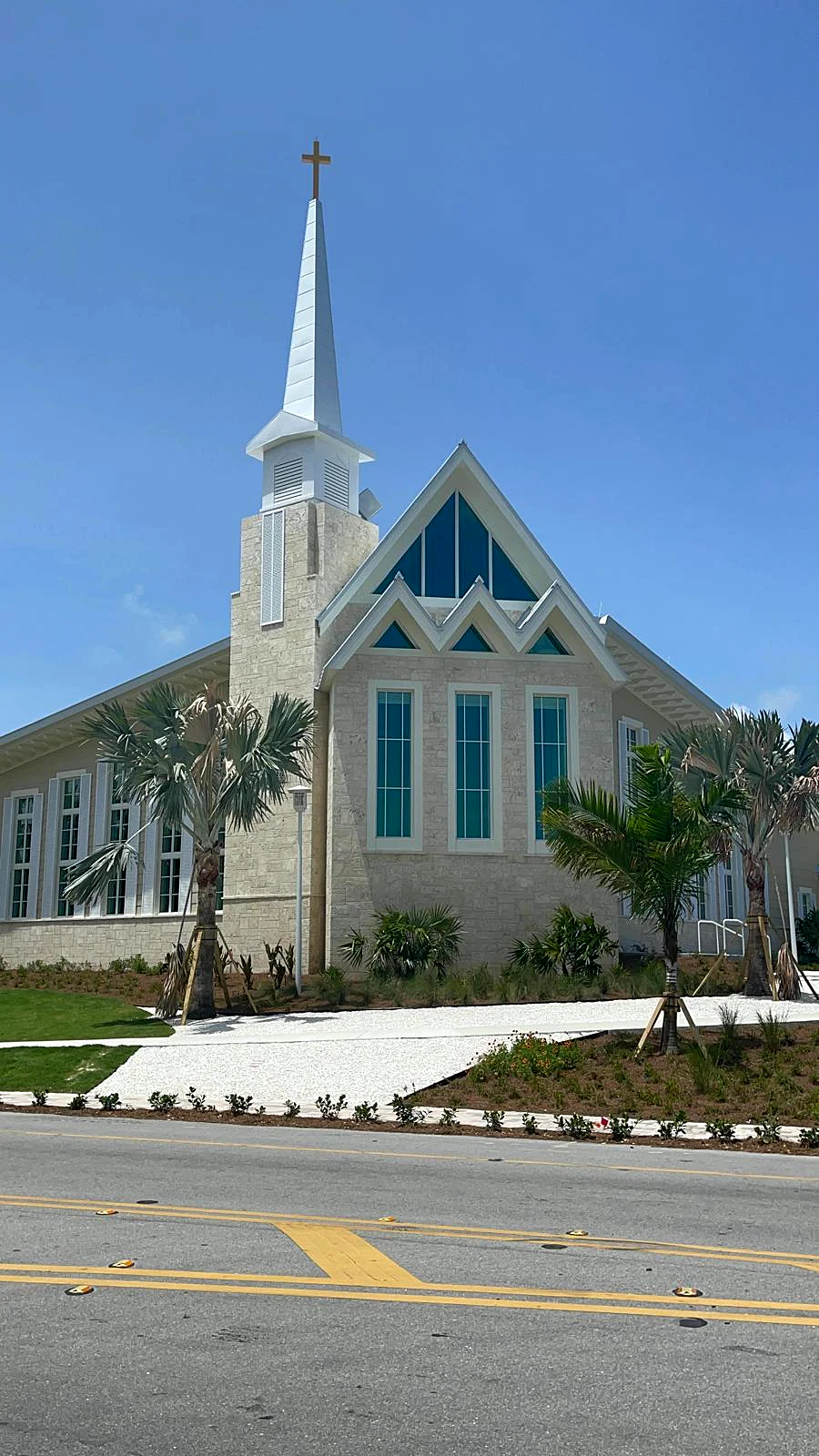A South Florida church with a white steeple and freshly painted exterior
